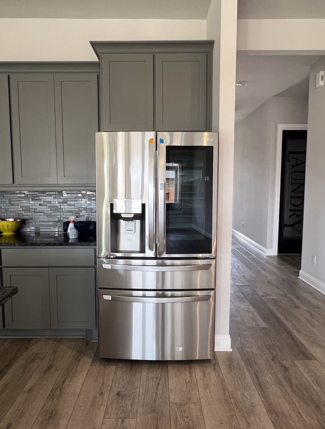 Stainless four-door InstaView refrigerator installed in a cabinet surround